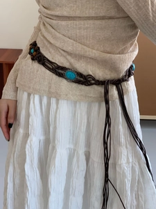 Bohemian wax rope waist chain with turquoise oval stone and wooden beads on a white skirt