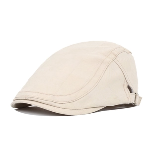 Close-up of beige flat cap showing cotton twill fabric and side metal adjustment buckle
