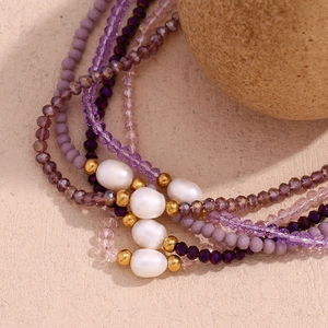 Detail of purple crystal beaded necklace featuring white freshwater pearls and gold beads