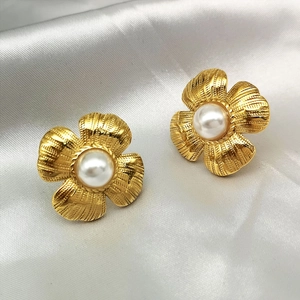 Vintage style 18K gold plated flower stud earrings with center pearl on white silk fabric