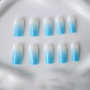 Blue and white gradient glossy long square press-on nails displayed on a ceramic tray