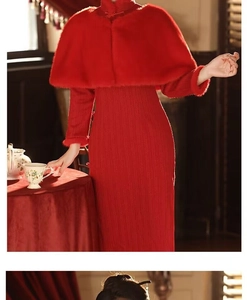Detail of red faux fur shawl with tassel fringe paired with a knit stand-collar dress