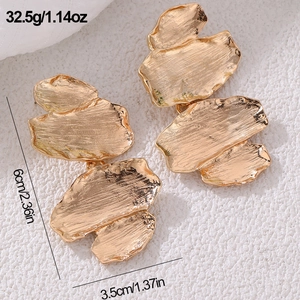 Close-up of golden irregular leaf earrings with hammered texture and 6cm size detail