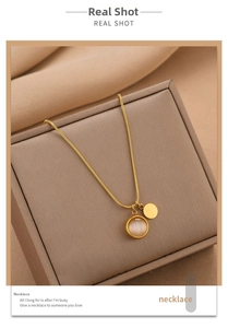 Détail du collier en acier titane doré avec pierre œil de chat et pendentif disque