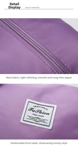 Close-up of durable zipper and white woven label on purple waterproof travel duffel bag