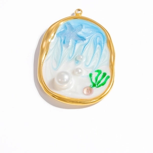 Macro detail of oval gold seashell pendant with blue resin and miniature pearl inlay