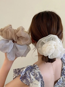 Detailed view of oversized organza scrunchies in beige, light blue, and pearl white colors
