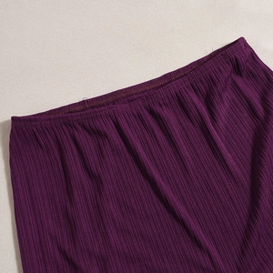 Detailed view of dark purple ribbed knit fabric showing high-quality stitching and texture