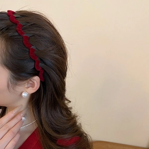 Detail of red flocked wave headband and large pearl earring on model for elegant style
