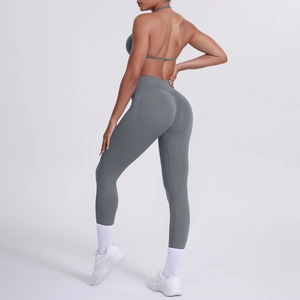 Dettaglio dei leggings yoga grigi a vita alta e reggiseno sportivo su modella fitness