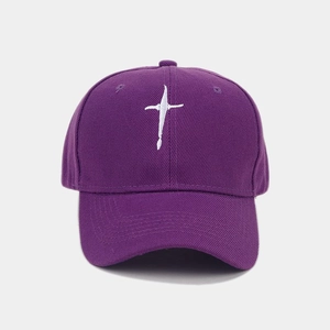 Close-up of a purple twill baseball cap with white cross embroidery and curved brim