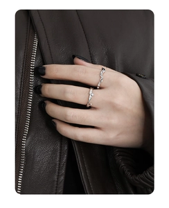Detail of silver irregular branch-textured open ring with a single zircon on hand