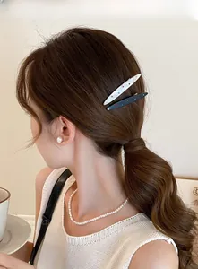 Détail de barrettes en acrylique à strass portées par un mannequin avec des perles
