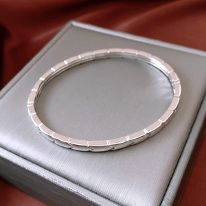 Détail macro du bracelet argenté à motif fléché sur boîte à bijoux en soie
