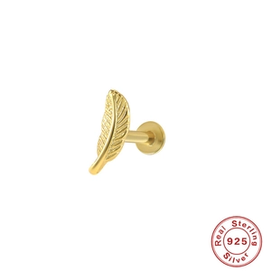 Close-up of golden feather labret stud made of certified 925 sterling silver