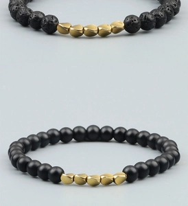 Macro shot of lava stone and matte black beads with irregular gold metal accents