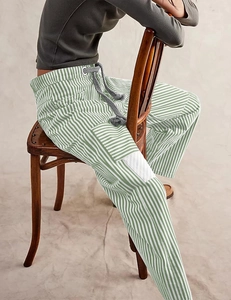Detail of green and white striped casual pants with drawstring waist and side cargo pocket
