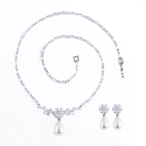Elegant jewelry set with silver zircon necklace and teardrop pearl earrings on white backdrop