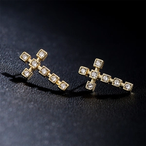 Boucles d'oreilles croix plaquées or 18 carats avec zircons blancs sur fond sombre