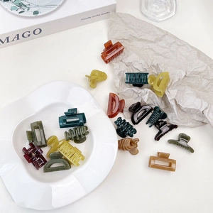 Detailed close-up of colorful resin hair claws in jelly texture on a white decorative plate