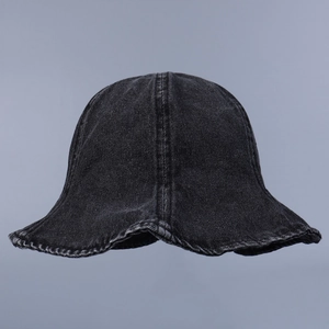 Gros plan détaillé de la texture du denim noir délavé sur un chapeau bob rétro