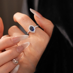 Macro view of zircon hollowed diamond flower ring with sapphire blue oval gemstone