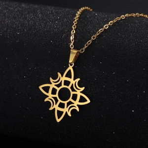 Détail macro d'un pendentif soleil poli en acier inoxydable doré sur une chaîne en O