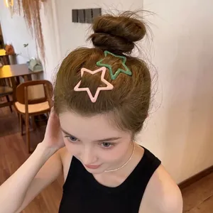 Pair of minimalist hollow star hair clips in pastel pink and green on model hair