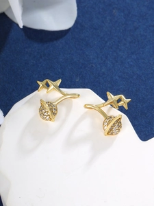 Macro detail of gold planet and stars earrings with sparkling micro-pave cubic zirconia