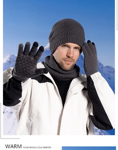 Close-up of winter knit beanie set with neck warmer and touch-screen gloves in the snow