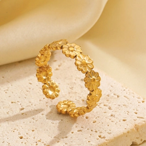 Minimalist gold daisy flower open ring in stainless steel on a stone pedestal with silk