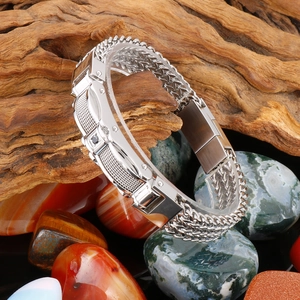 Macro shot of men's stainless steel bracelet with woven chain and black gemstone inlay
