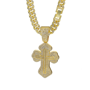 Detailed close-up of golden iced out Cuban link chain with a large encrusted cross pendant