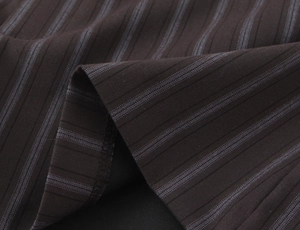 Close-up of fine vertical pinstripe fabric texture on brown slim fit casual shorts