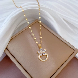 Detail of gold titanium steel flower necklace with sparkling micro-inlaid crystals