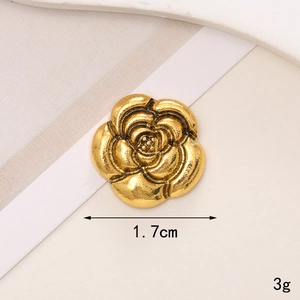 Macro shot of a vintage gold camellia flower button charm for DIY phone cases and shoes
