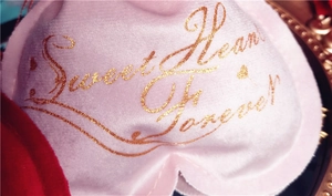 Macro shot of pink velvet heart gift bag with golden Sweet Heart Forever text
