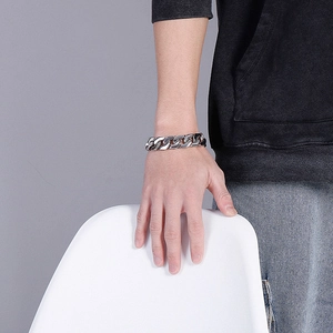 Men's silver Cuban link bracelet in stainless steel shown worn by model on wrist