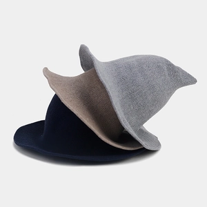 Close-up of knitted pointed witch hats in grey, khaki and navy blue with wavy brims