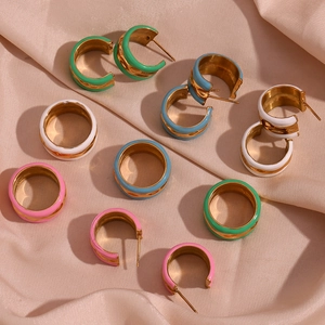 Detail of colorful enamel water ripple rings on pink silk fabric background