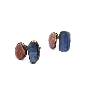 Macro shot of natural pink and blue raw crystals on bronze ring bases with textured finish