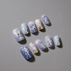 Blue and purple galaxy themed press-on nails with butterfly patterns and rhinestones