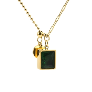 Detail of emerald green square pendant on a layered gold snake and clip chain