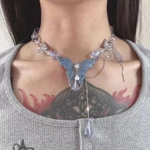 Close-up of Y2K style necklace featuring a large blue butterfly pendant and clear beads