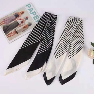 Detail view of monochrome plaid scarves with herringbone pattern and fringe on white background