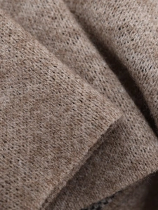 Close-up of earth-tone chunky knit texture with detailed wool blend stitch patterns