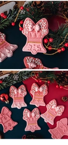 Close-up of pink bell-shaped fondant cookies with embossed reindeer and bow details