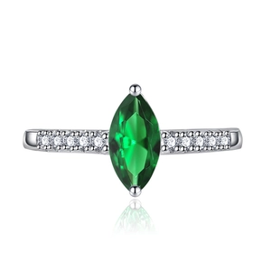 Macro shot of marquise-cut green gemstone ring with side diamond accents on white base