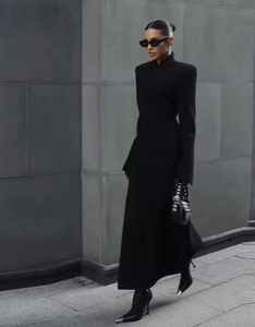 Détail d'une robe longue noire ajustée avec talons hauts dans un style urbain et minimaliste