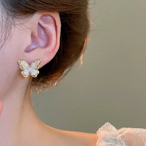 18k gold plated butterfly stud earrings with pink zircon and white enamel on model